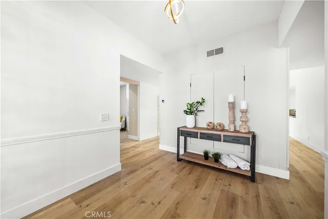 a view of a hallway with wooden floor and furniture