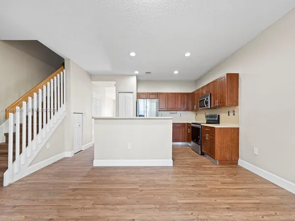 a view of kitchen with wooden floor and electronic appliances