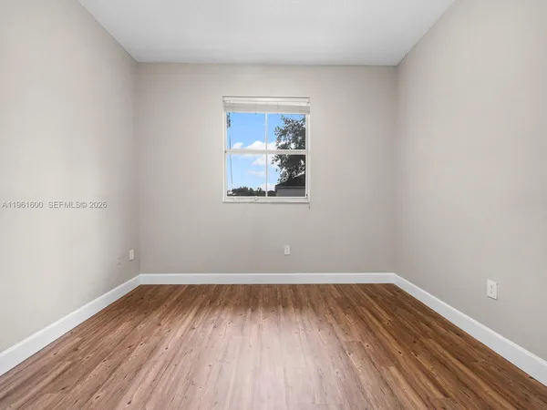 a view of room with window and wooden floor