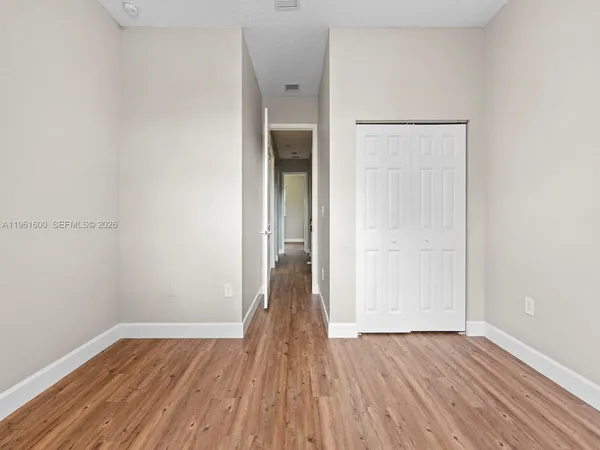 a view of a room with wooden floor and a window