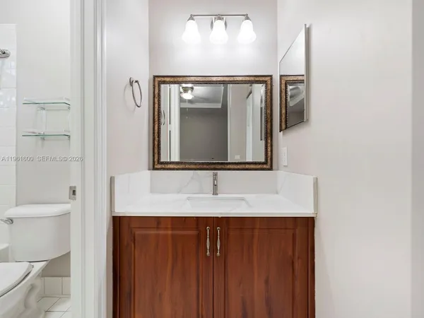 a bathroom with a granite countertop sink and a mirror