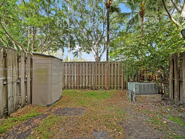 a view of backyard with small cabin and wooden fence