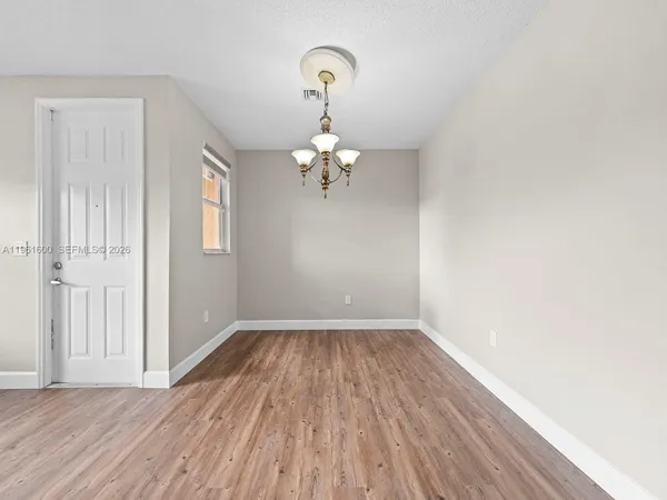 a view of a room with wooden floor closet and windows