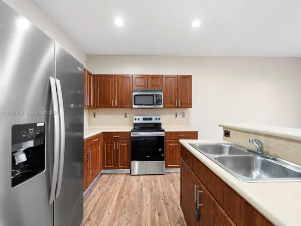 a kitchen with stainless steel appliances granite countertop a refrigerator stove and sink