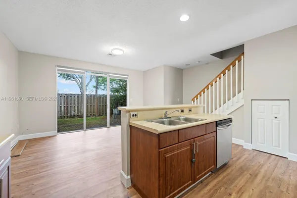 a kitchen with a sink and wooden floor