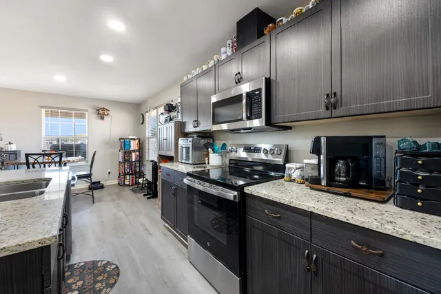 a kitchen with stainless steel appliances granite countertop a sink stove and refrigerator