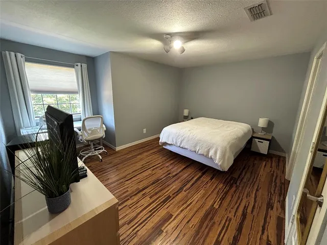 a bedroom with a bed and large windows