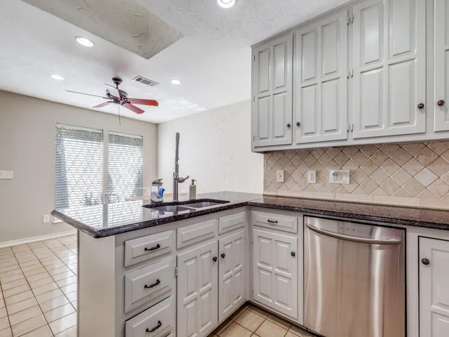 a kitchen with white cabinets and a sink