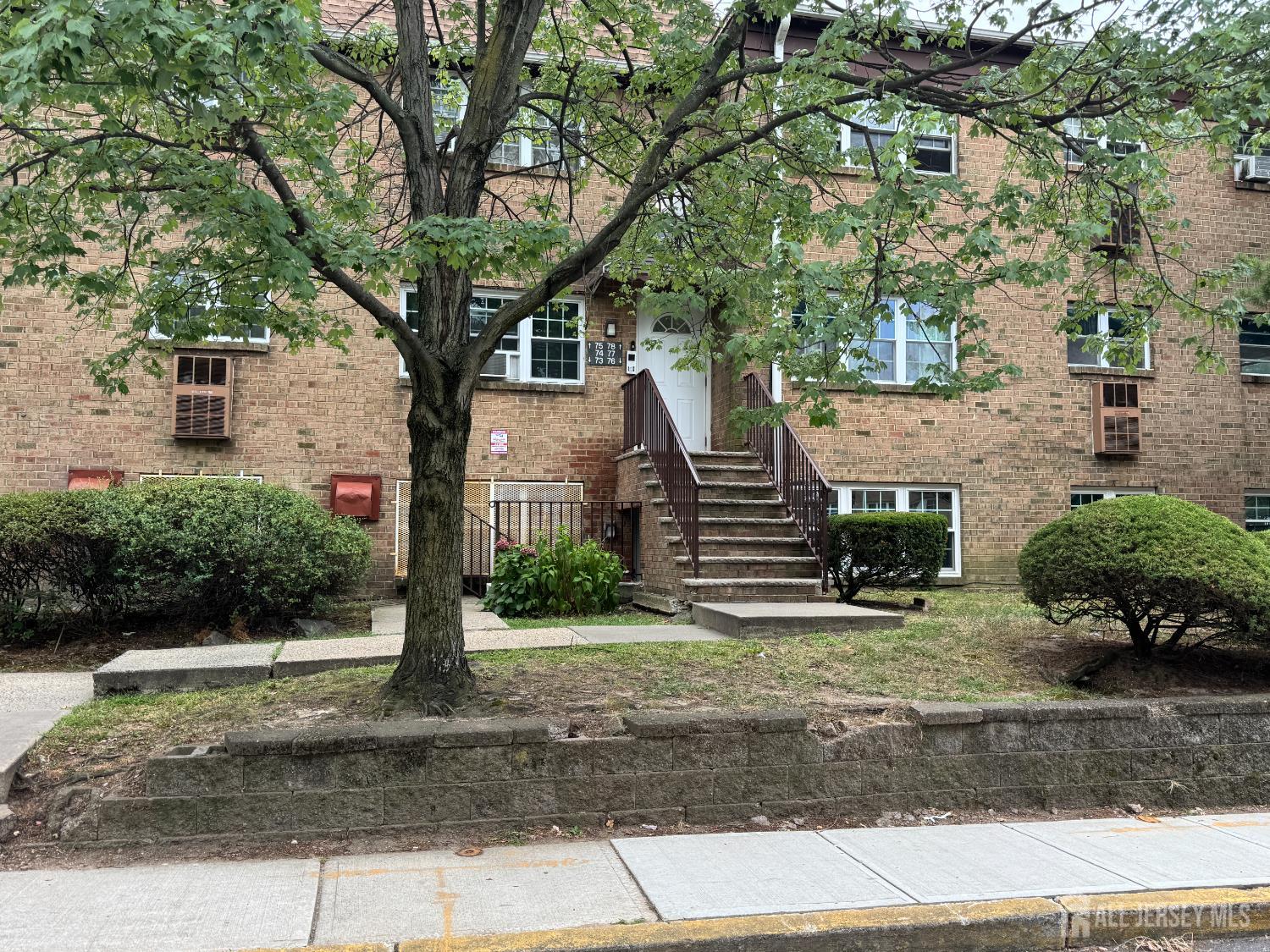 76 College Drive Edison, NJ 08817 - Photo 2 of 16 a front view of a house with a yard and a garage