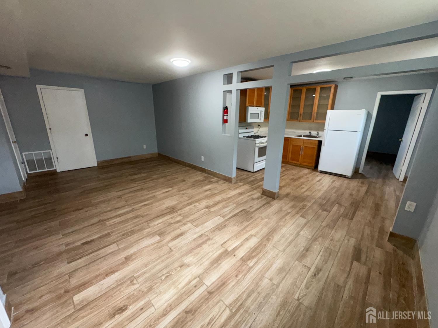 76 College Drive Edison, NJ 08817 - Photo 5 of 16 a view of a kitchen with wooden floor and electronic appliances
