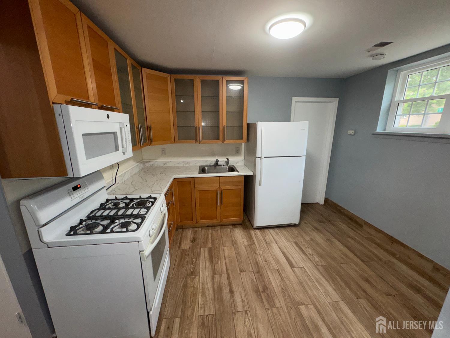 76 College Drive Edison, NJ 08817 - Photo 7 of 16 a kitchen with a refrigerator a stove top oven a sink and dishwasher with wooden floor