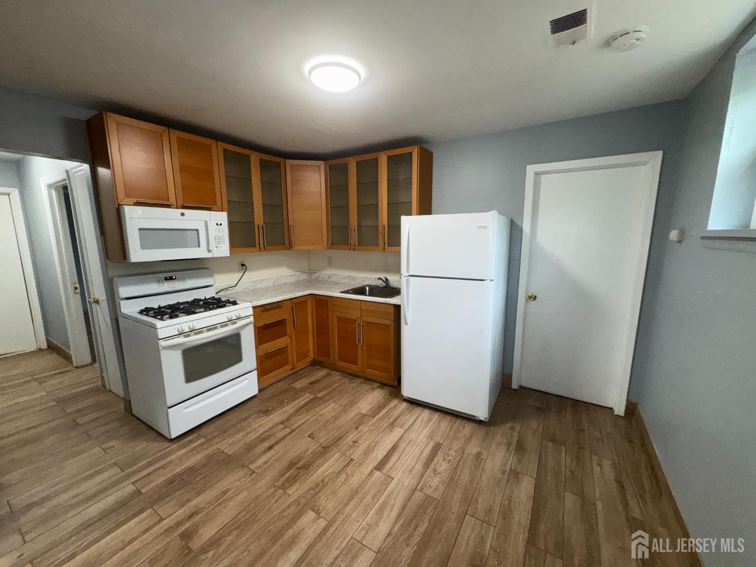 76 College Drive Edison, NJ 08817 - Photo 8 of 16 a kitchen with a refrigerator and a stove top oven