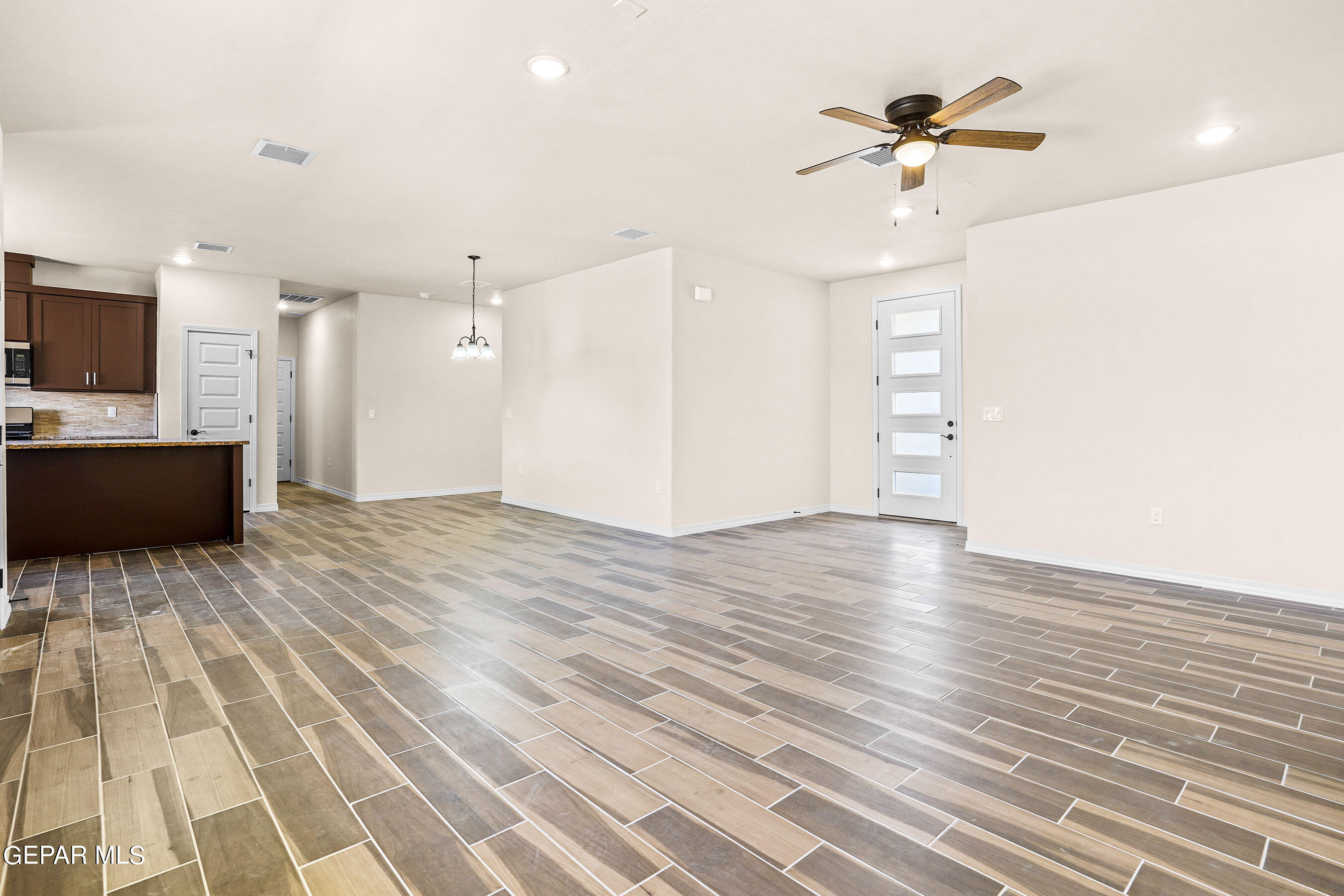 871 Country Club Road, Unit 4E El Paso, TX 79932 - Photo 9 of 34 a view of empty room with wooden floor and fan