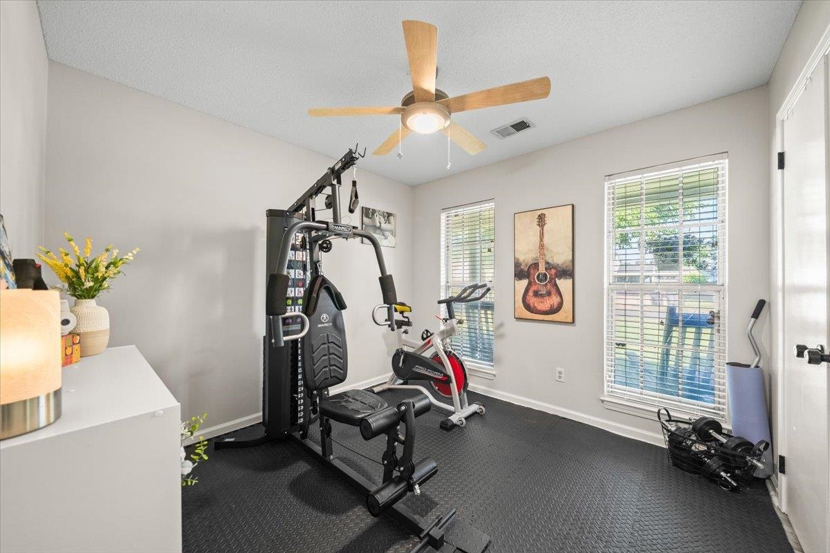7300 Country Side Road Memphis, TN 38133 - Photo 16 of 22 Interior room featuring textured rubber flooring, light gray walls, and two large windows with horizontal blinds