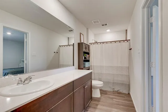 a bathroom with a double vanity sink toilet mirror and shower