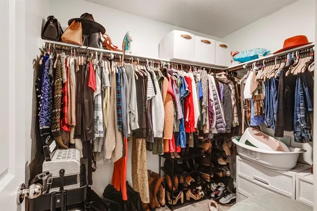 a view of walk in closet with clothes and shoes