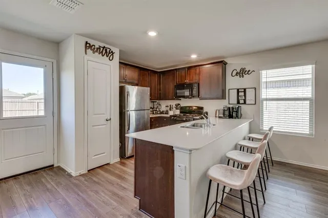 a kitchen with a refrigerator a stove a sink and a microwave