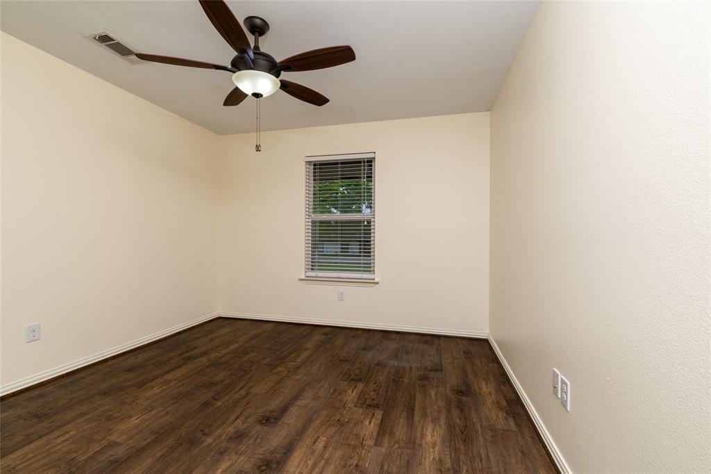 405 Kimbrough Road Azle, TX 76020 - Photo 25 of 39 an empty room with wooden floor ceiling fan and windows