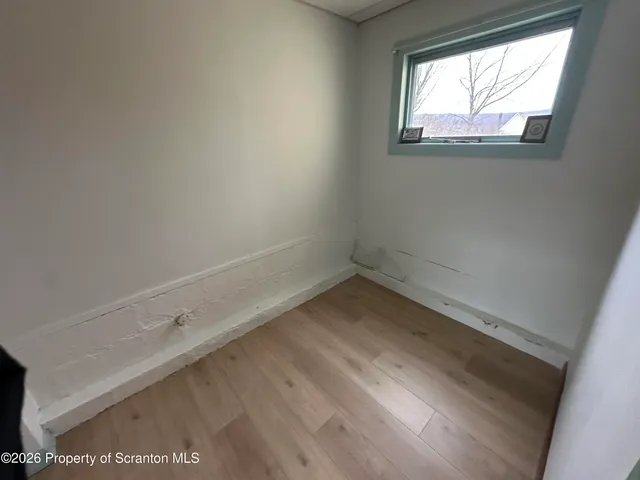 a view of a small space with wooden floor and a window