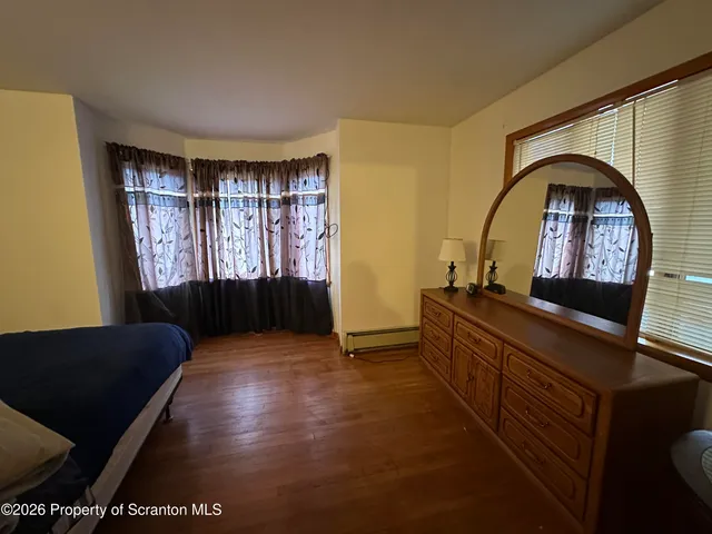 a living room with a couch and a dresser next to a window