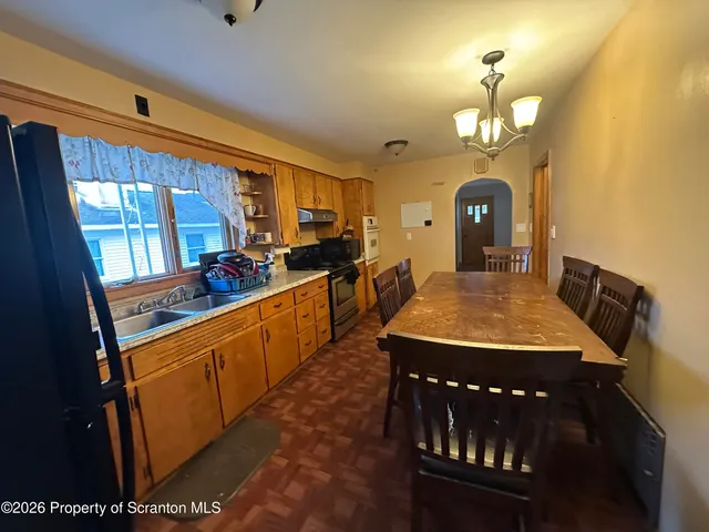 a view of a dining room with furniture a chandelier and wooden floor