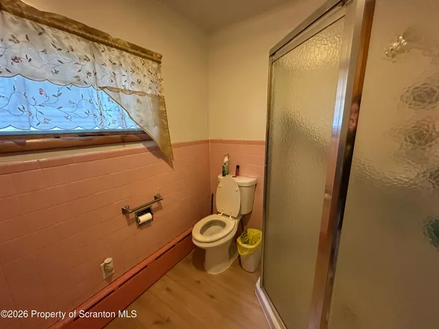 a bathroom with a toilet and a shower