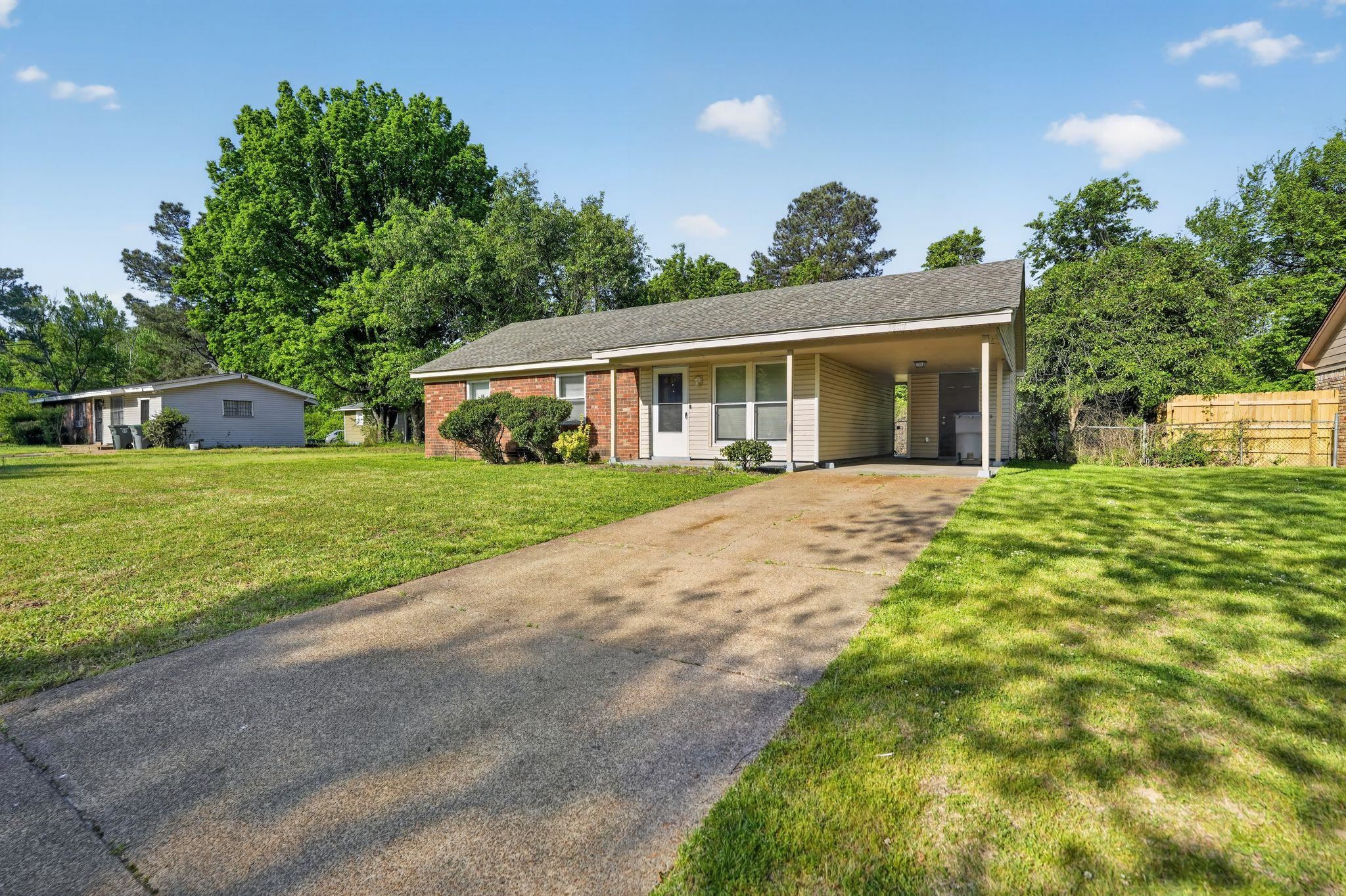 4587 Appleville Street Memphis, TN 38109 - Photo 1 of 34 Ranch-style home featuring concrete driveway, an attached carport, covered porch, brick siding, and a shingled roof