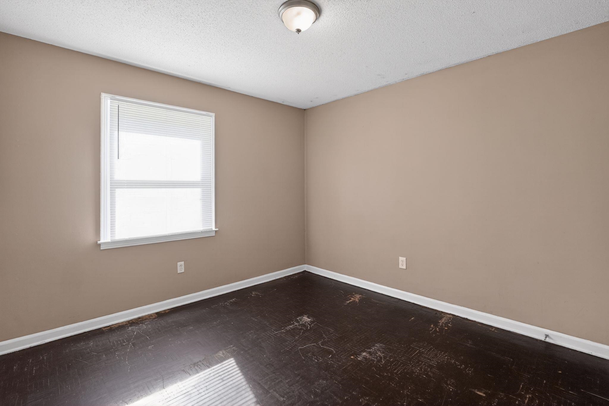 4587 Appleville Street Memphis, TN 38109 - Photo 11 of 34 Spare room featuring a textured ceiling and dark wood-style flooring
