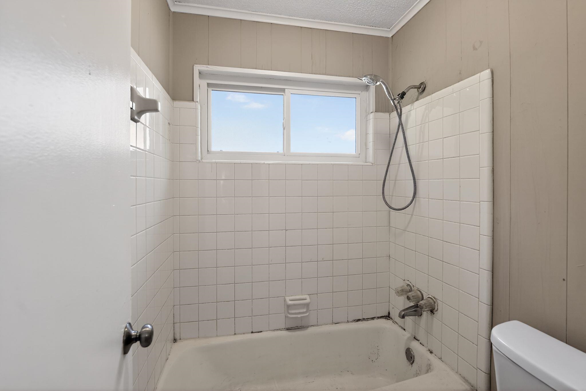4587 Appleville Street Memphis, TN 38109 - Photo 24 of 34 Bathroom with ornamental molding, wood walls, and shower / bath combination