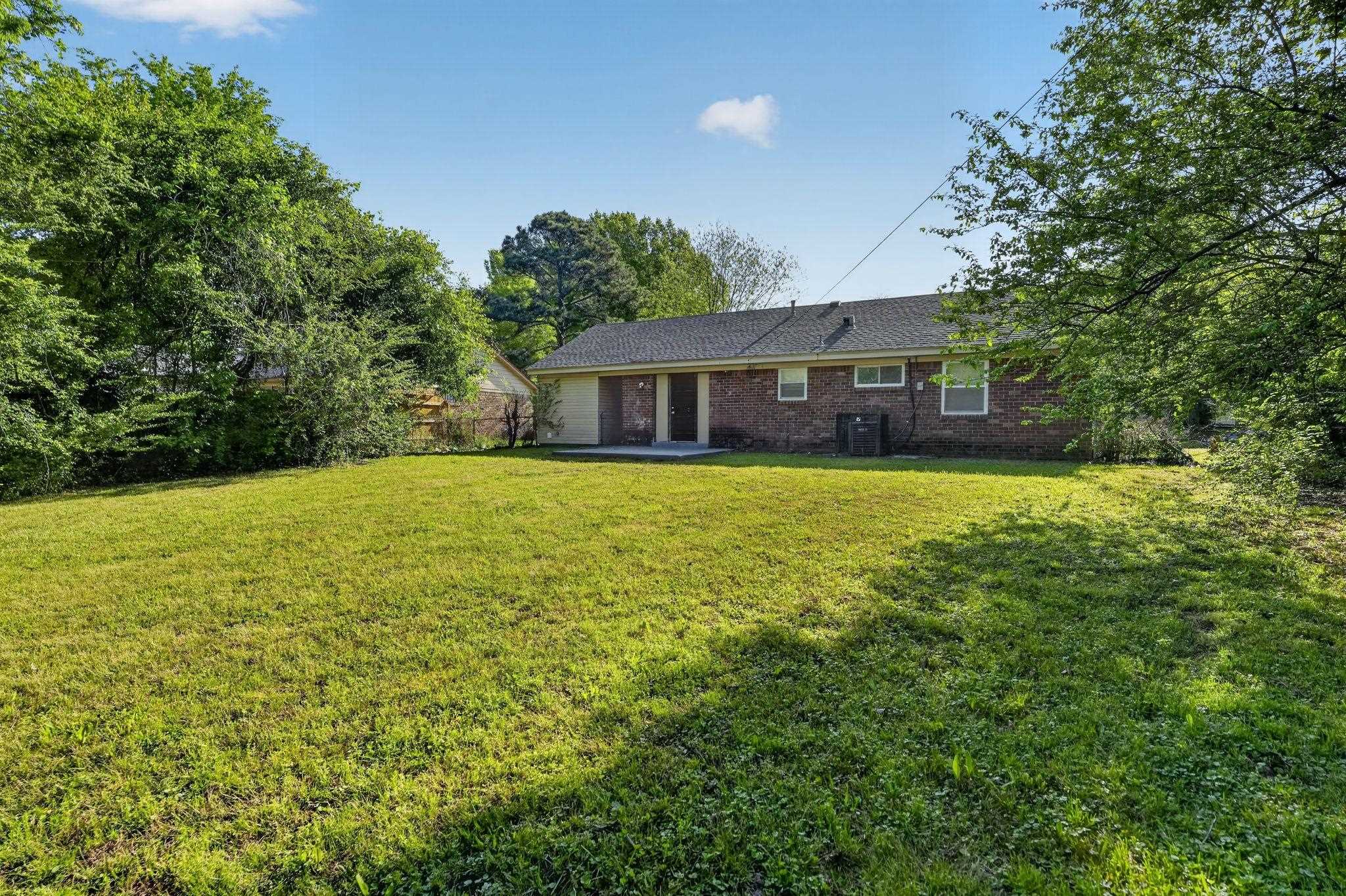 4587 Appleville Street Memphis, TN 38109 - Photo 28 of 34 Rear view of house featuring a lawn, brick siding, and a patio