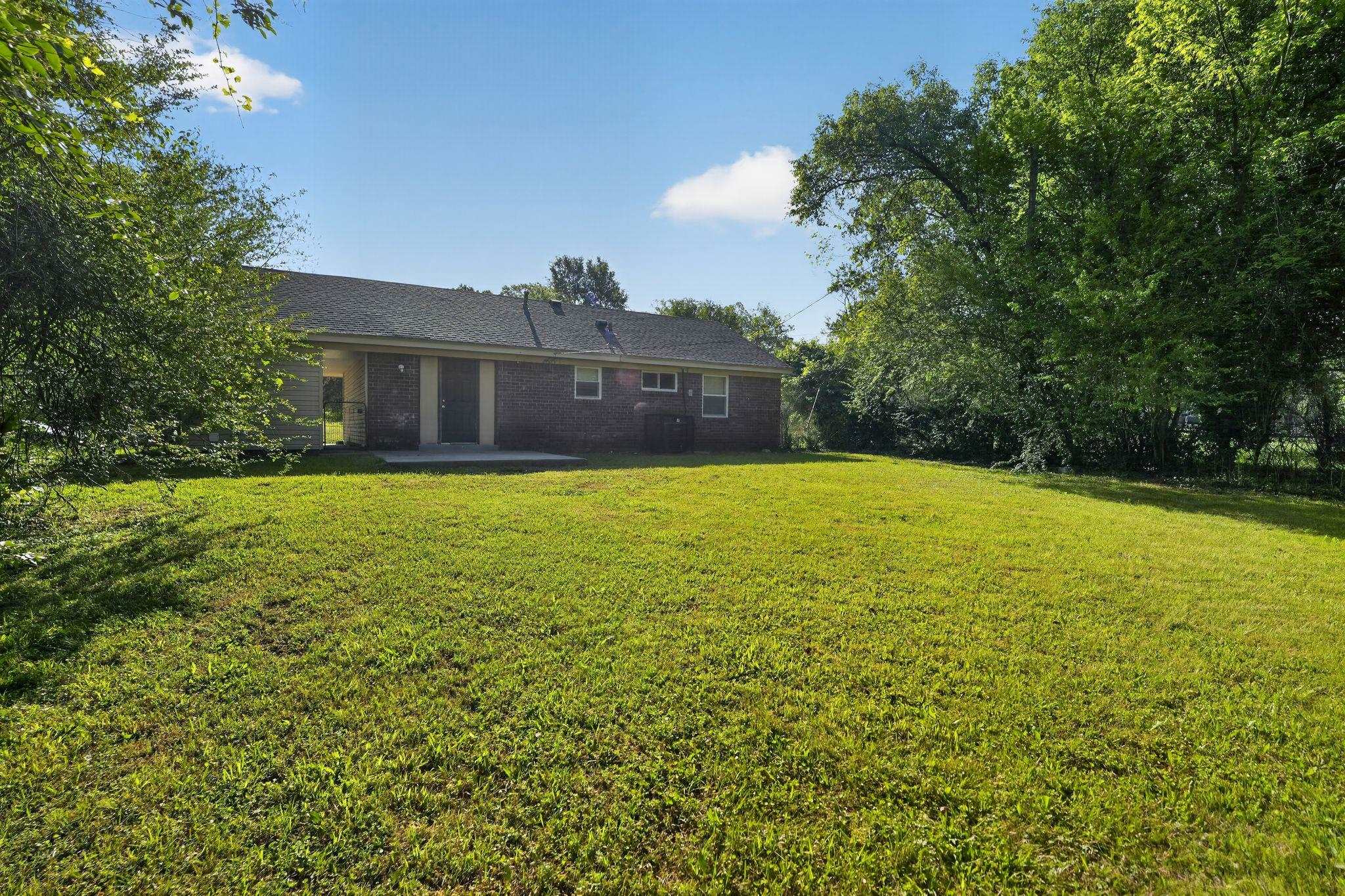 4587 Appleville Street Memphis, TN 38109 - Photo 30 of 34 Back of house featuring a yard, brick siding, and a patio