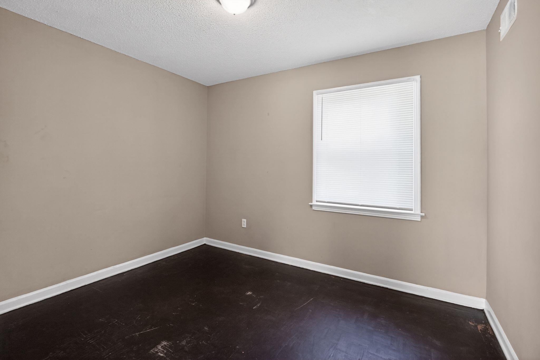 4587 Appleville Street Memphis, TN 38109 - Photo 5 of 34 Spare room with dark wood-style flooring and a textured ceiling