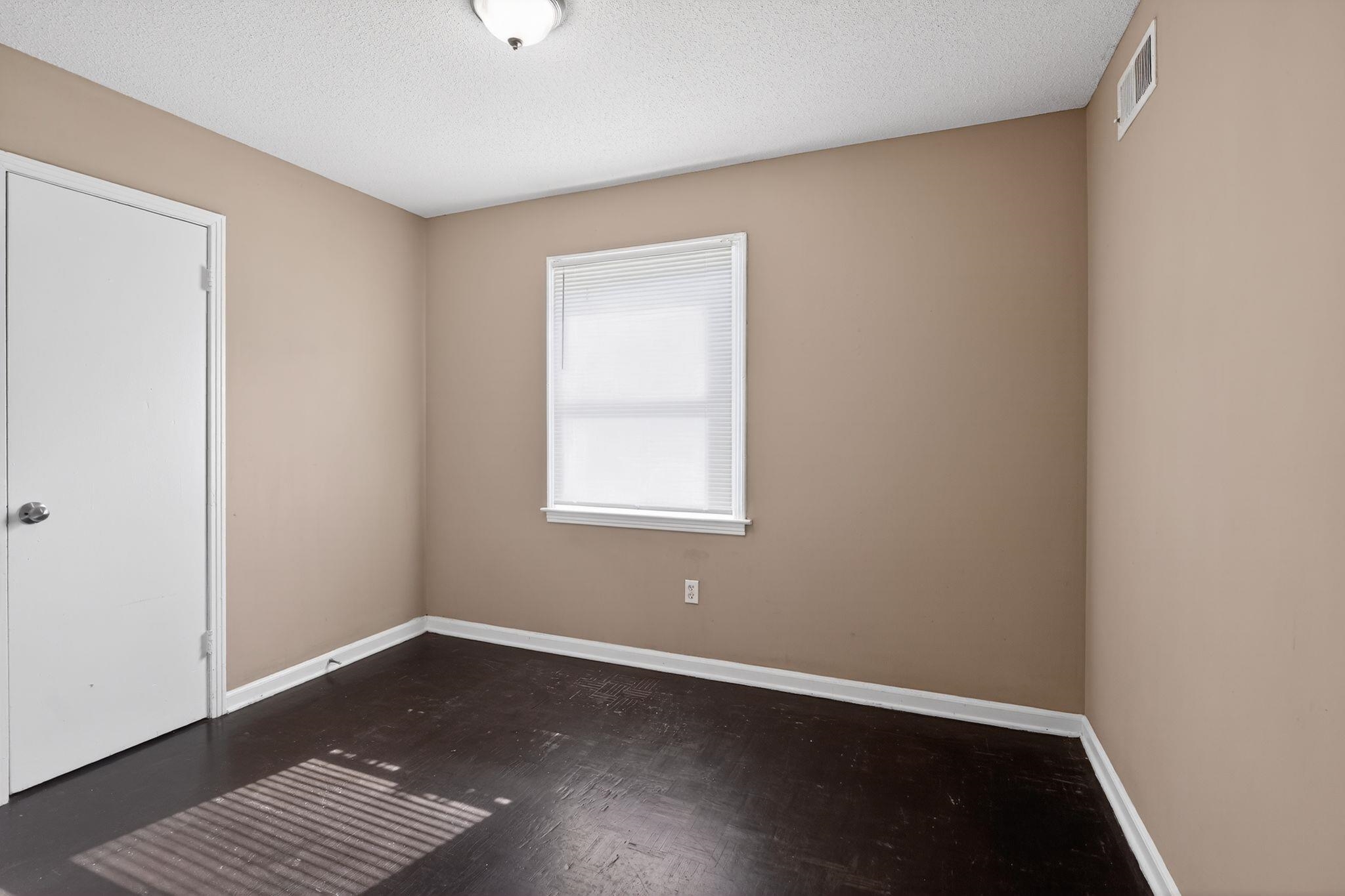 4587 Appleville Street Memphis, TN 38109 - Photo 8 of 34 Spare room with a textured ceiling and dark wood finished floors