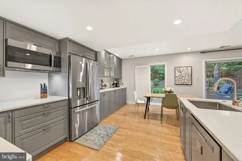 a kitchen with granite countertop a refrigerator and a sink