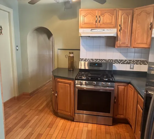 a kitchen with wooden floors and stainless steel appliances