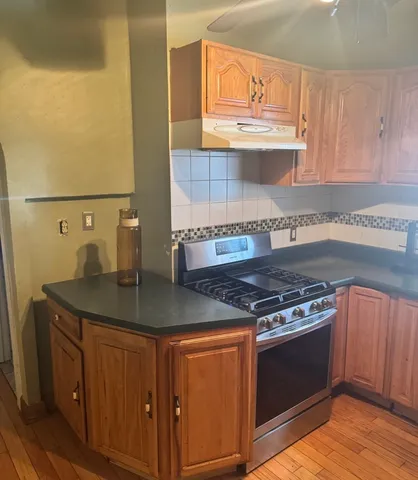 a kitchen with stainless steel appliances granite countertop a sink stove and cabinets