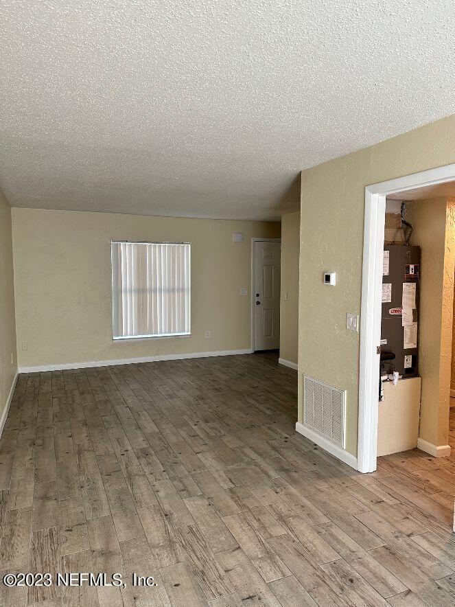 58 Masters Drive, Unit B St. Augustine, FL 32084 - Photo 2 of 10 an empty room with wooden floor and windows
