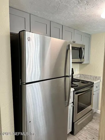 a white refrigerator freezer and a stove sitting inside of a kitchen