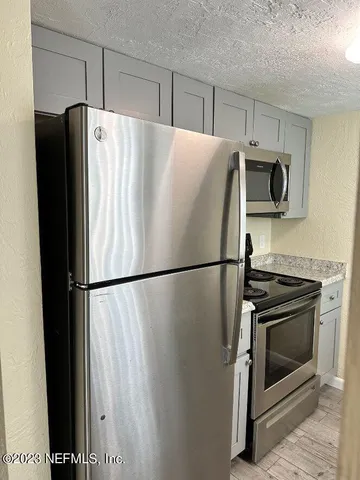 a white refrigerator freezer and a stove sitting inside of a kitchen
