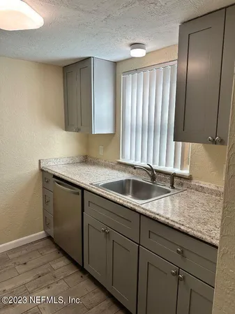 a kitchen with granite countertop cabinets sink and window