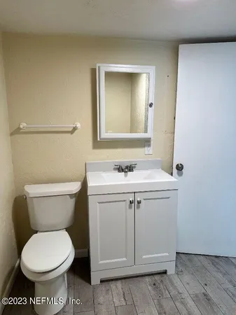 a bathroom with a toilet sink and mirror
