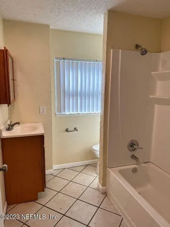a bathroom with a tub a sink and a shower