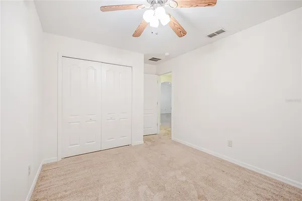 an empty room with a window and a ceiling fan