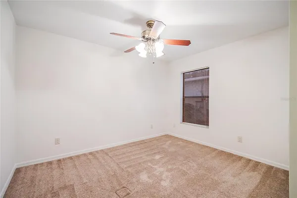 an empty room with a chandelier fan