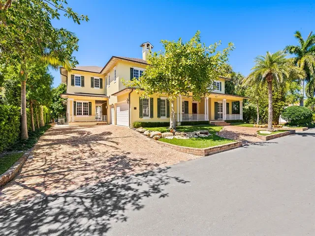 front view of a house with a swimming pool and a yard