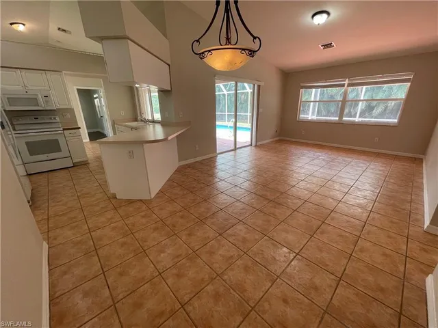 a view of a kitchen with furniture and stainless steel appliances