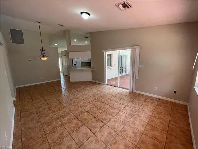 a view of a big room with wooden floor and windows