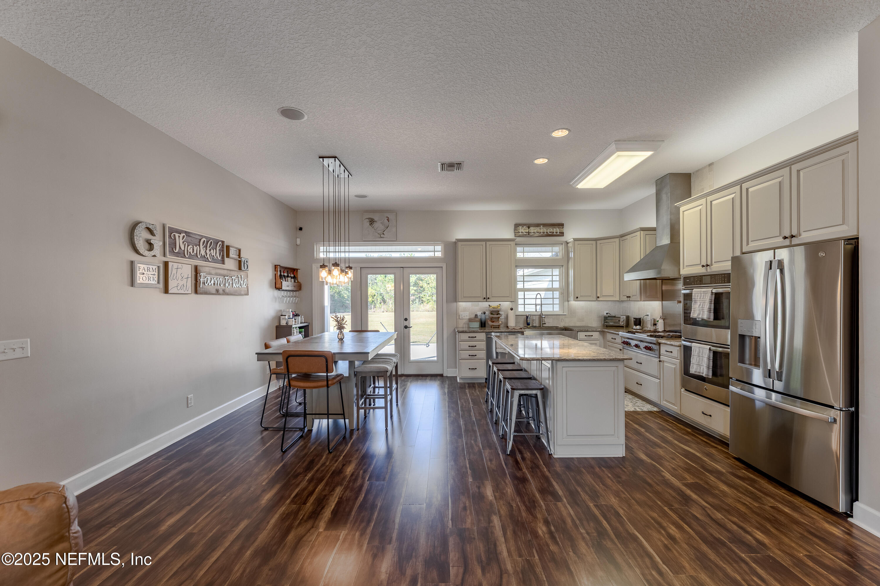 3670 Charles Green Road Hilliard, FL 32046 - Photo 19 of 68 a kitchen with a table chairs refrigerator and microwave