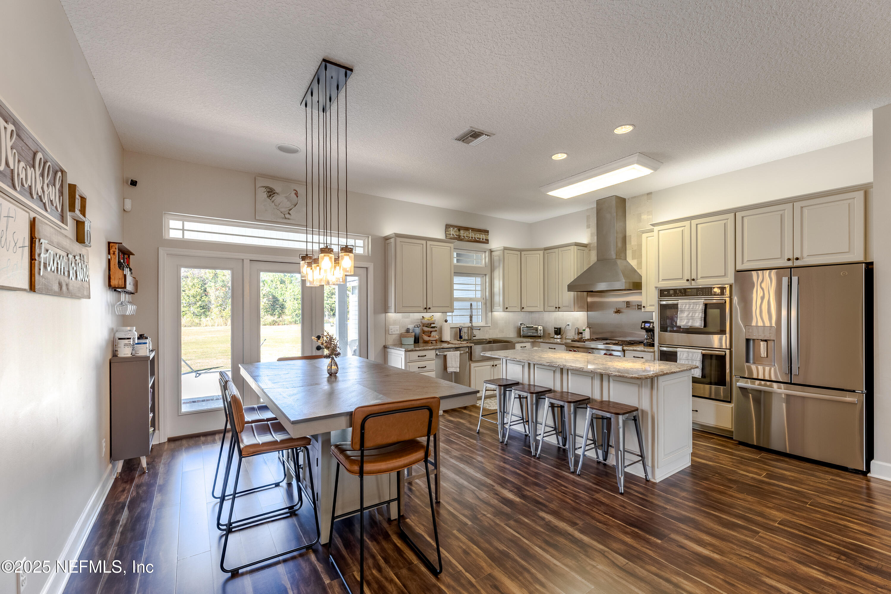 3670 Charles Green Road Hilliard, FL 32046 - Photo 20 of 68 a kitchen with stainless steel appliances granite countertop a stove refrigerator a dining table and chairs with wooden floor