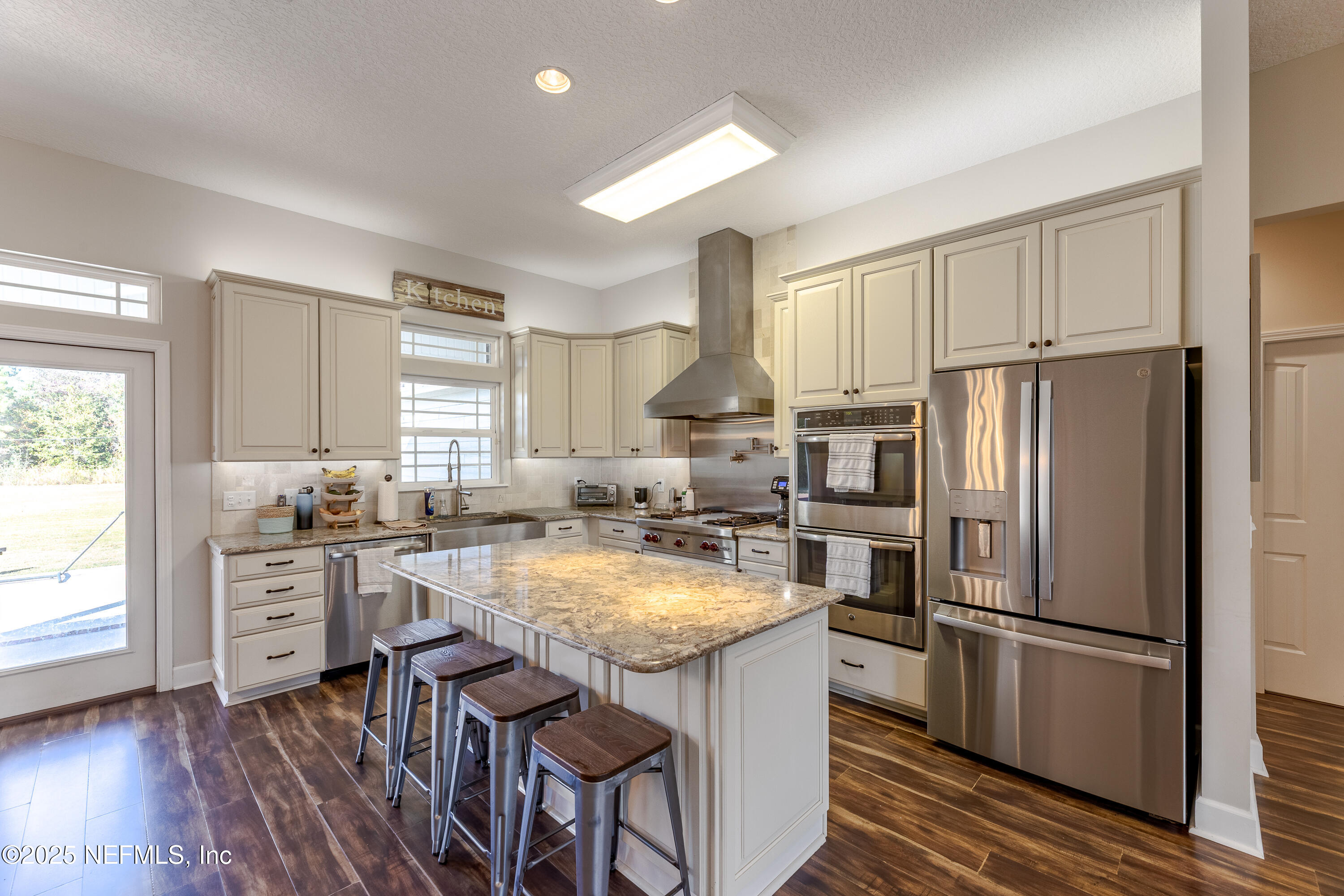 3670 Charles Green Road Hilliard, FL 32046 - Photo 22 of 68 a kitchen with stainless steel appliances granite countertop a refrigerator a sink a stove and white cabinets